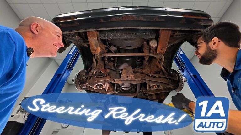 A mechanic using a breaker bar and sockets to remove the steering linkage from a Chevrolet S10 truck.