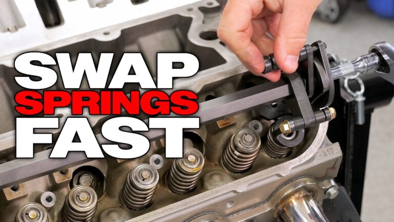 A technician demonstrating the Summit Racing Quick-Change LS Valve Spring Compressor on an LS engine head.